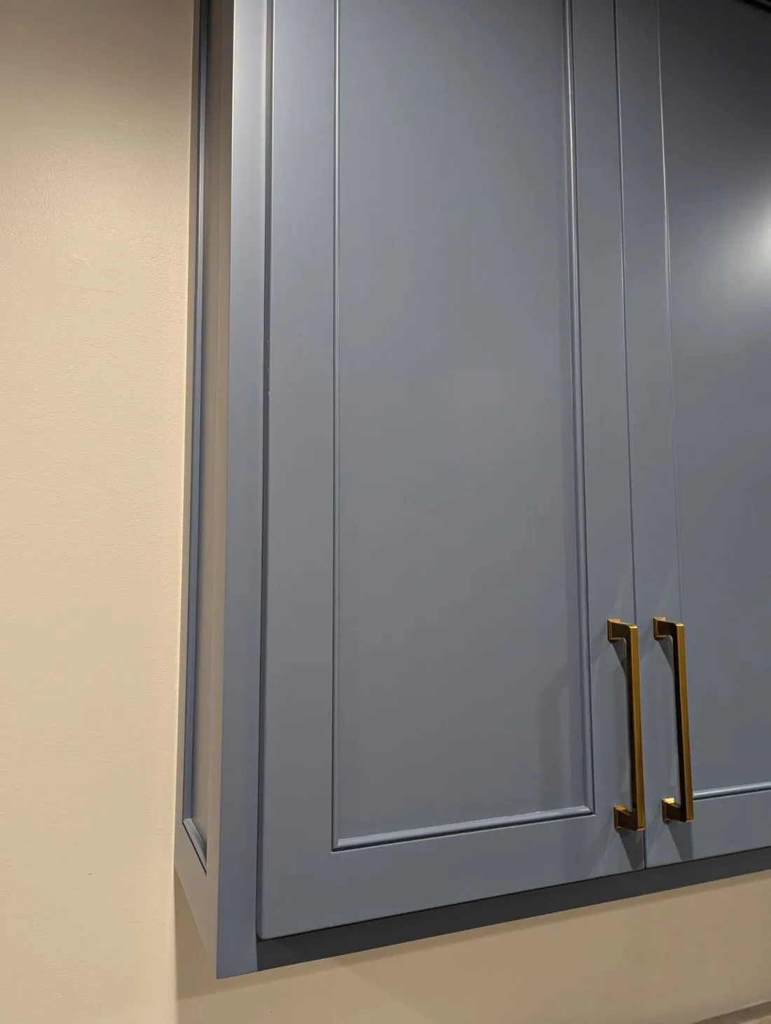 Blue grey overlay cabinet doors with brass bar pulls