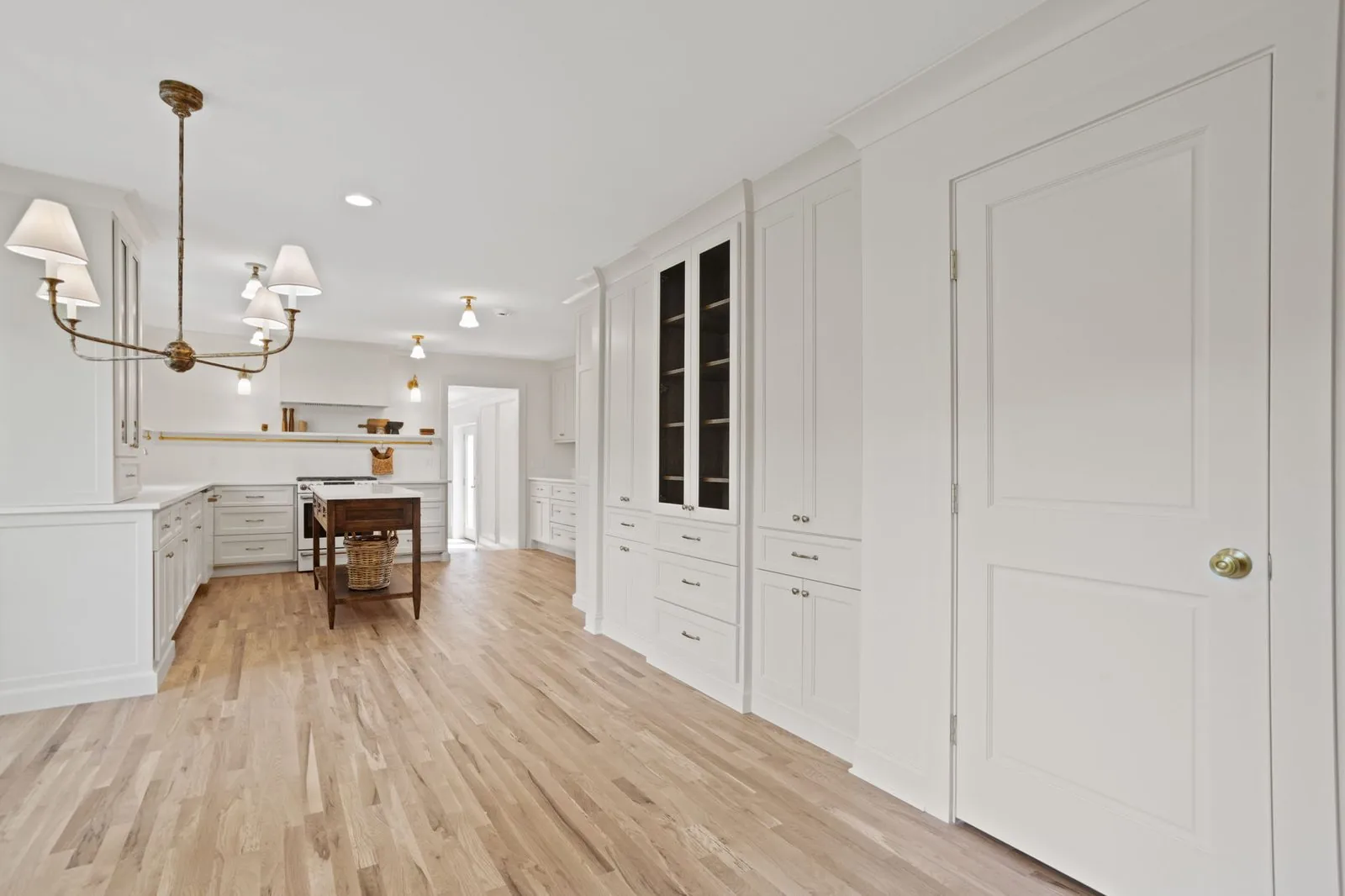 Hallway built-ins with glass fronted upper cabinets and paneled doors