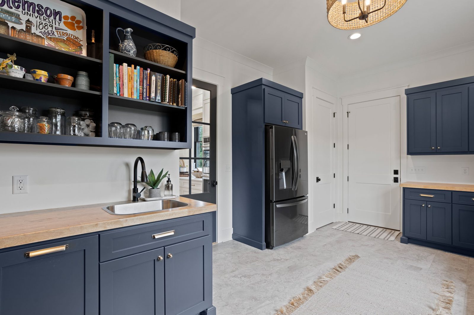 Navy butler pantry with open shelving, a wood counter and a prep sink