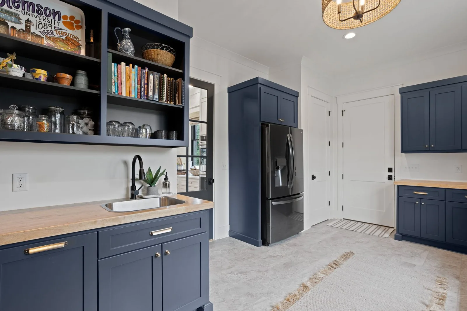 Navy butler pantry with open shelving, a wood counter and a prep sink