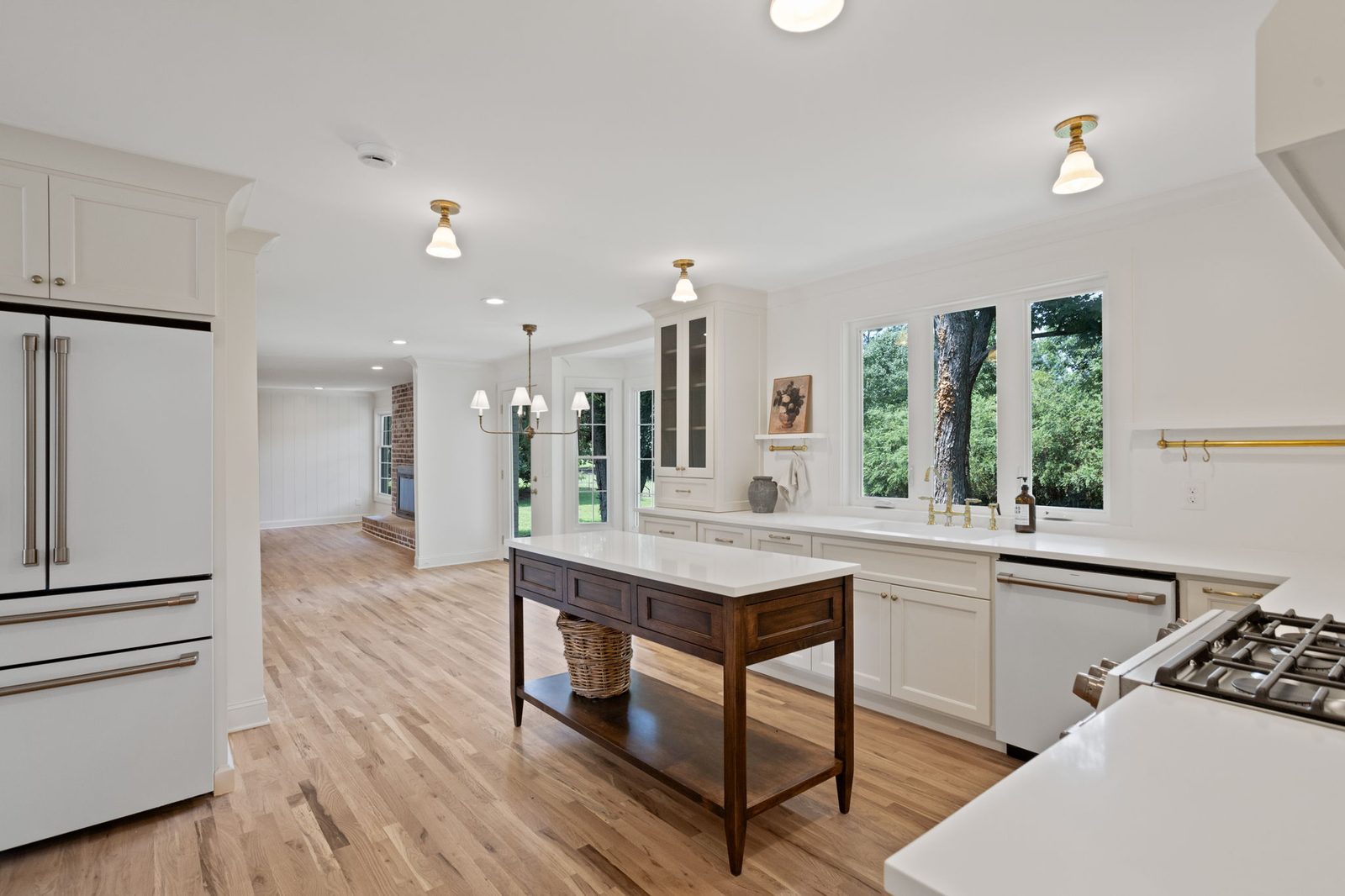 White kitchen with glass upper doors and a wood work table