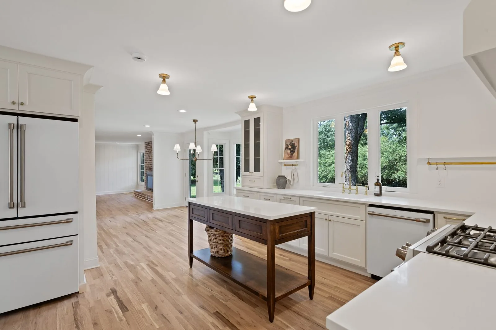 White kitchen with glass upper doors and a wood work table