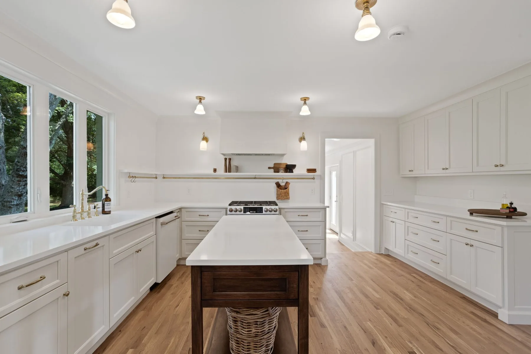White kitchen with a freestanding wood work table and stone counters